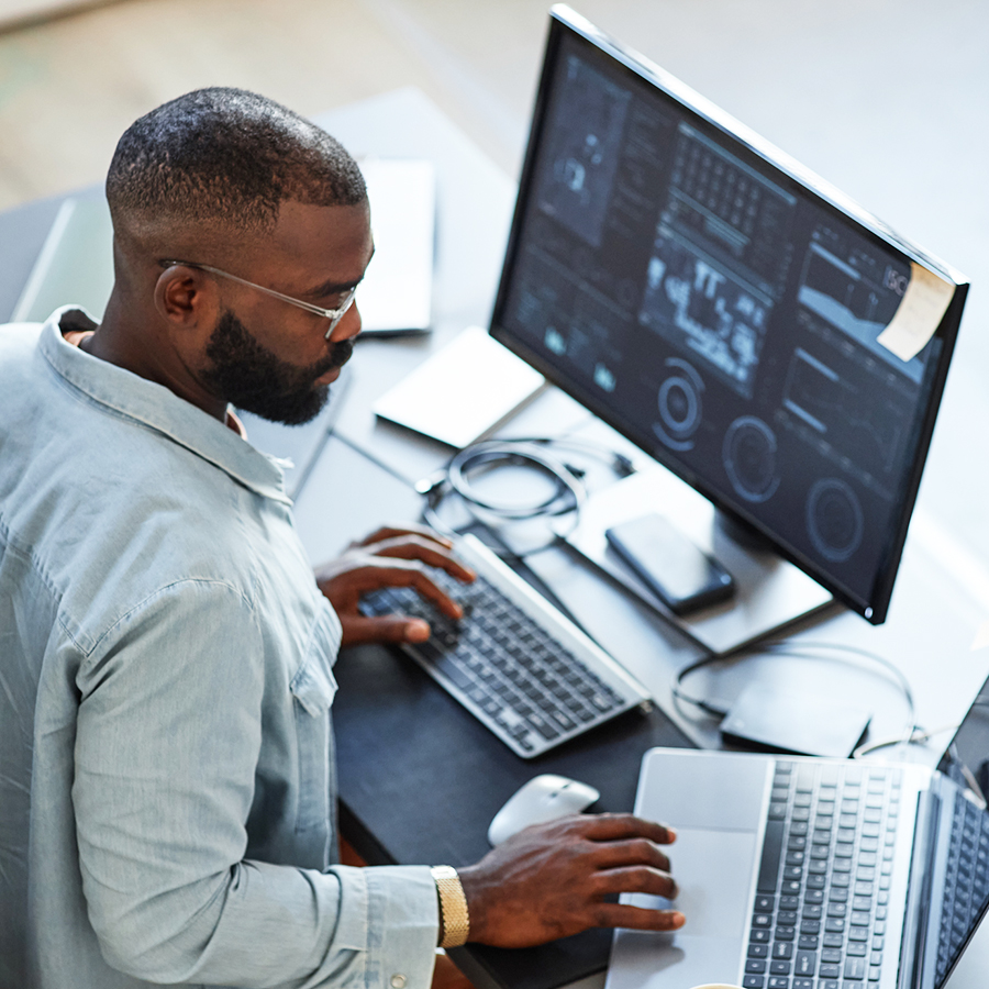 Homme en télétravail sur plusieurs postes de travail utilisant l'infogérance