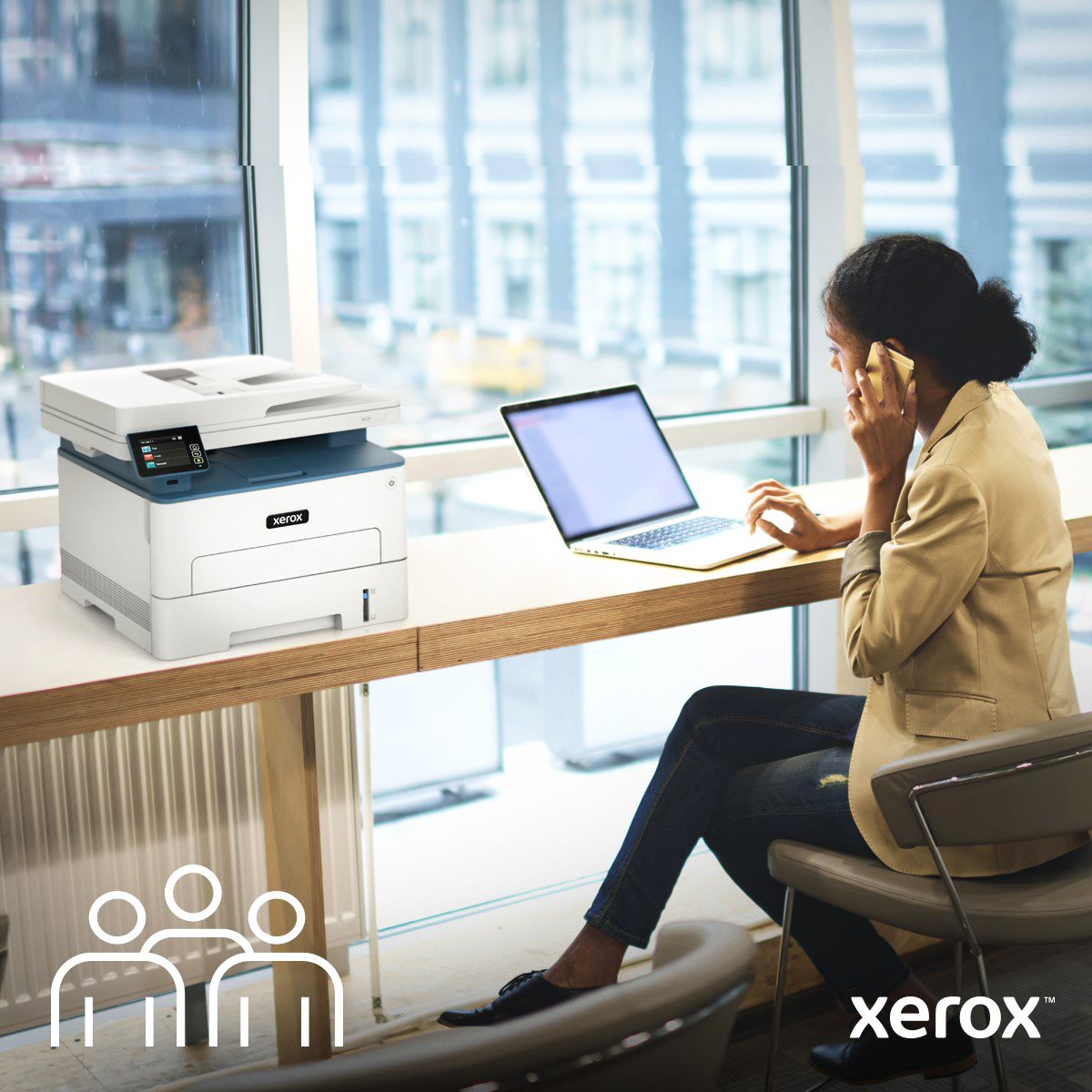 Femme au téléphone en télétravail et à côté d'une imprimante Xerox®.
