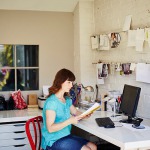 Femme en télétravail devant son cahier et son ordinateur à côté d'une Imprimante multifonction Xerox C315.