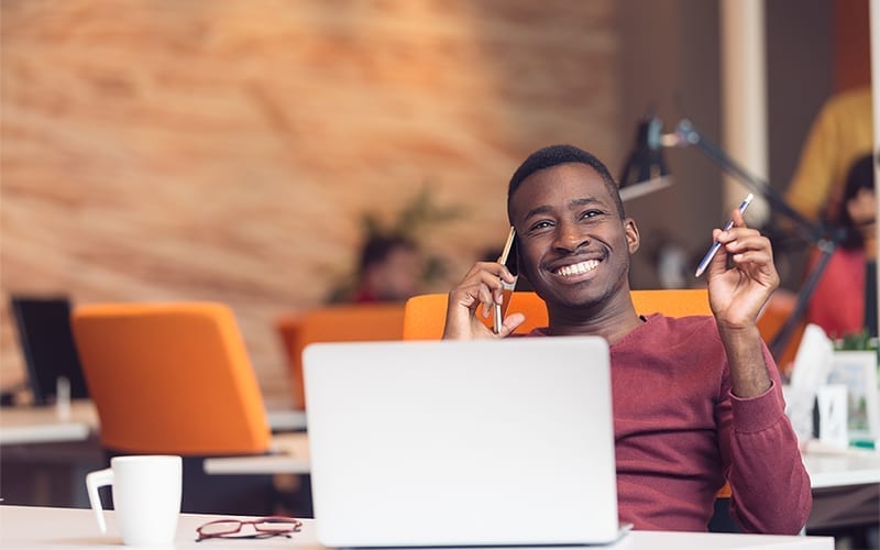 Hommes souriant avec un ordinateur