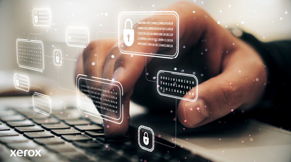 Xerox® ConnectKey® : fonctionnalités de sécurité avancées La main d'une personne tape sur un clavier d'ordinateur portable, avec des icônes de verrouillage numérique et de code binaire lumineuses superposées sur l'image, symbolisant une cybersécurité robuste et une protection des données.