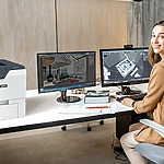 Femme dans un bureau à côté de l'imprimante Xerox® VersaLink® C620