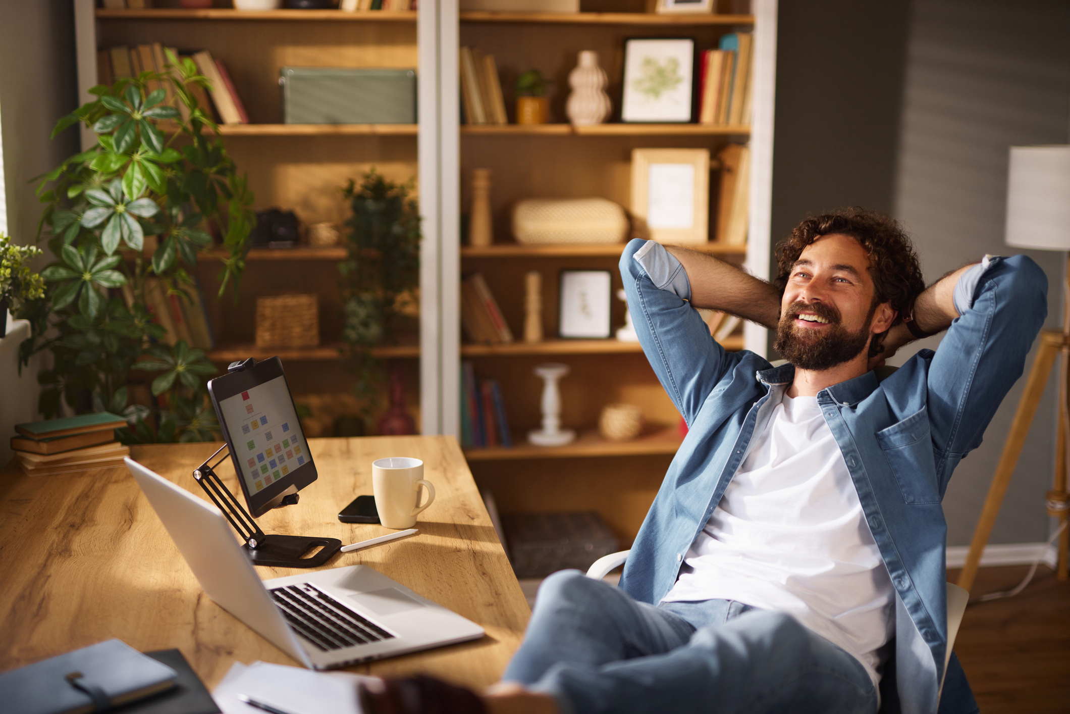 Freelancer relaxing with feet up at home office desk